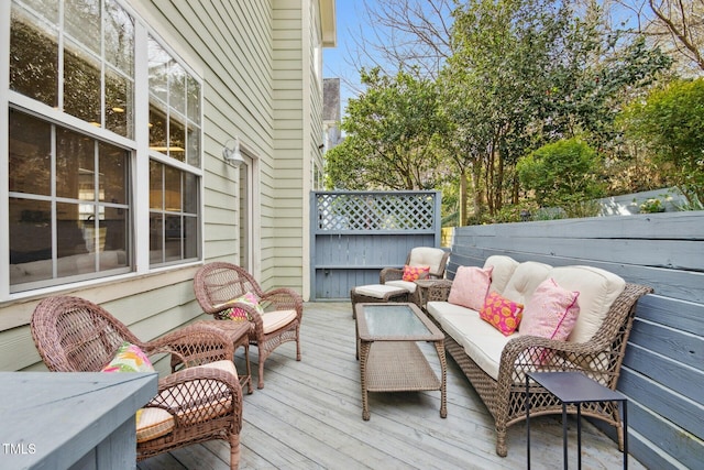 wooden terrace featuring outdoor lounge area and fence