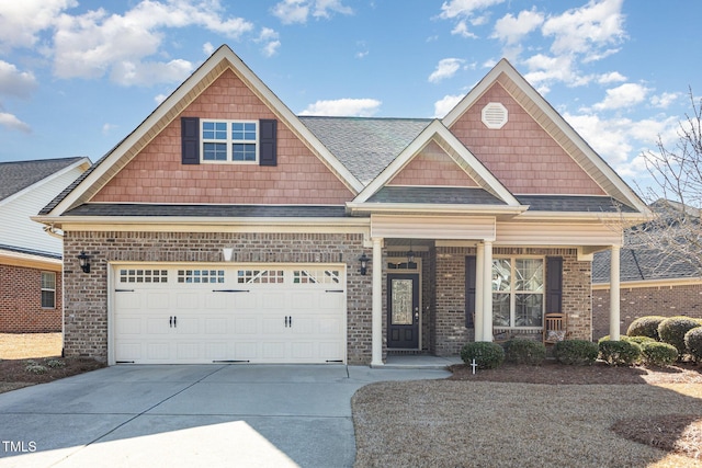 craftsman-style home with brick siding, a shingled roof, concrete driveway, covered porch, and a garage