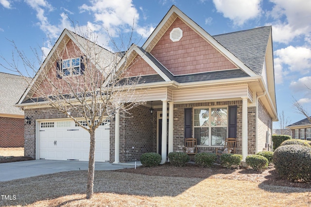 view of front of house with brick siding, a porch, concrete driveway, and a shingled roof