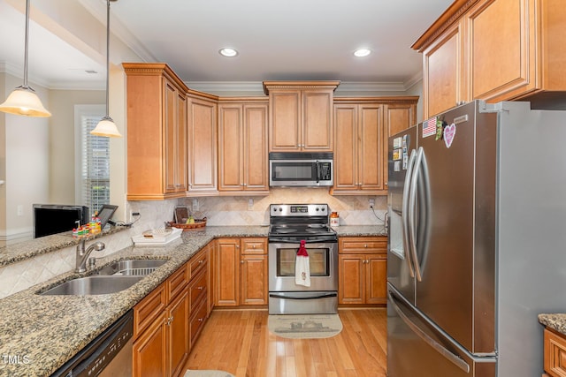 kitchen with light wood-style flooring, stainless steel appliances, crown molding, and a sink