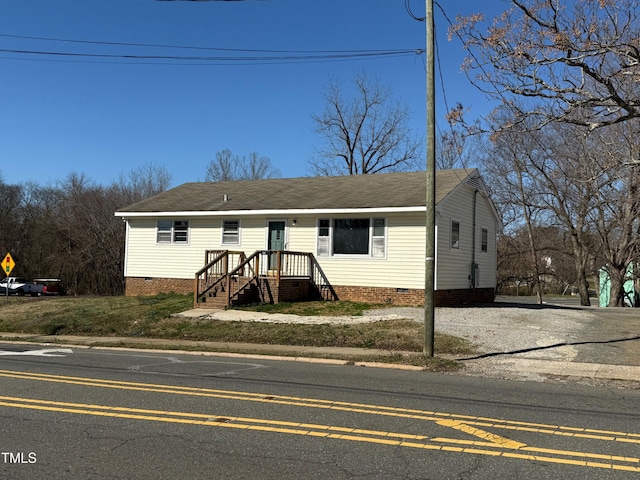 view of front of house with crawl space, roof with shingles, and driveway