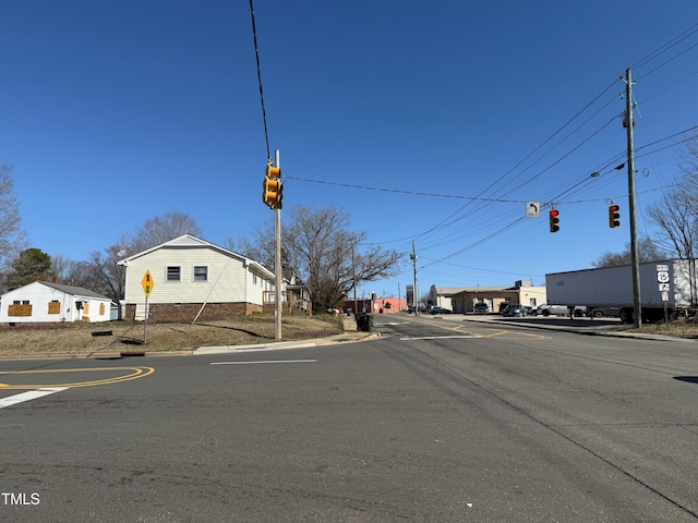 view of street with curbs, traffic signs, traffic lights, and sidewalks