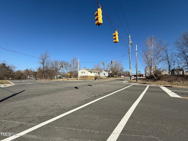 view of road featuring curbs, traffic signs, and traffic lights