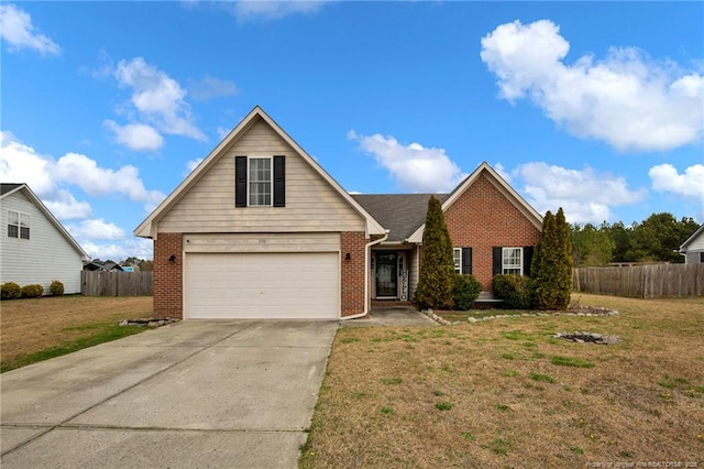 view of front of house featuring a front yard, fence, brick siding, and driveway