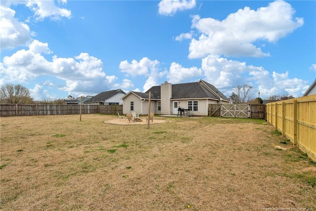 view of yard with a patio, a fenced backyard, and a gate