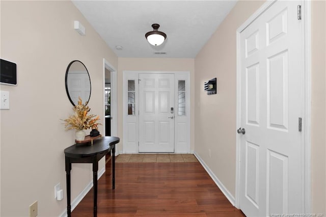 entrance foyer with dark wood finished floors, baseboards, and visible vents