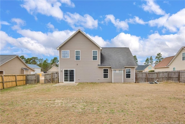 rear view of house with a patio, a yard, and a fenced backyard