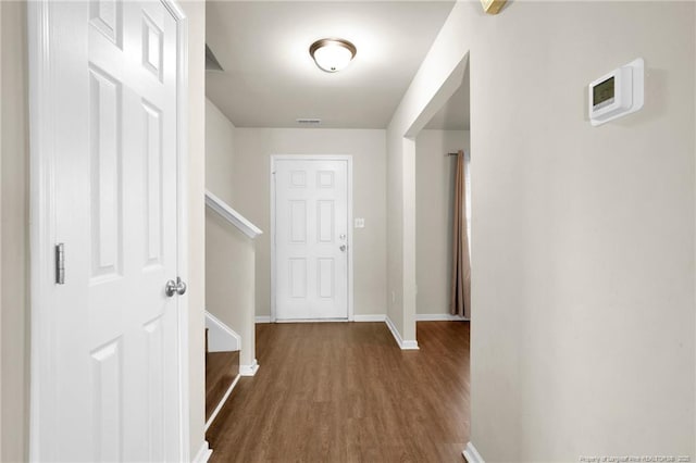 hall with visible vents, baseboards, wood finished floors, and stairs