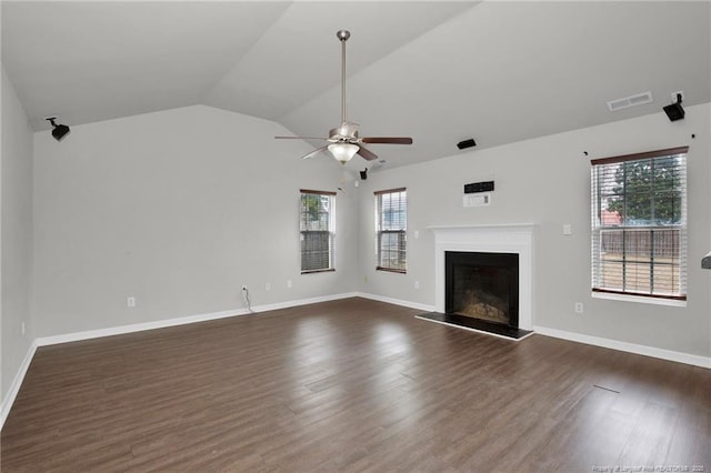 unfurnished living room featuring visible vents, a fireplace with raised hearth, ceiling fan, dark wood finished floors, and vaulted ceiling