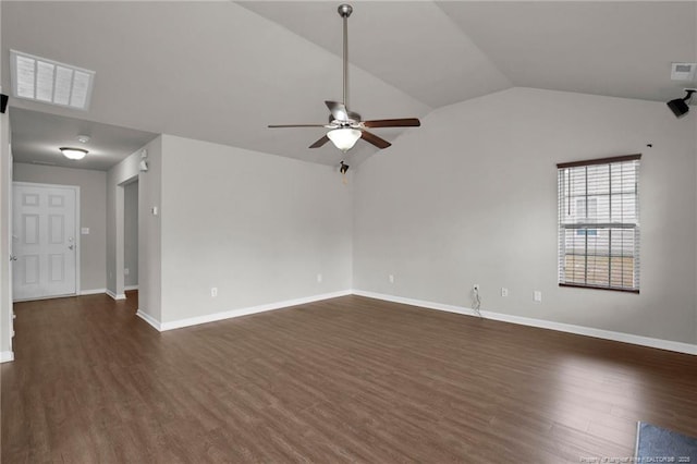 spare room featuring dark wood finished floors, vaulted ceiling, visible vents, and ceiling fan