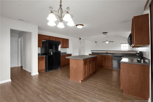 kitchen with dark countertops, visible vents, a sink, black appliances, and dark wood-style flooring