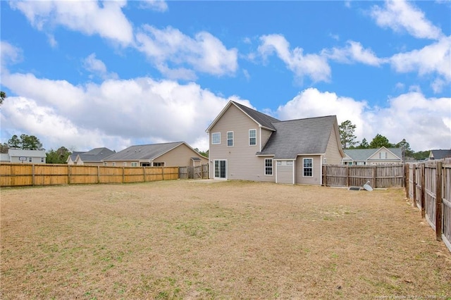 back of property with a yard and a fenced backyard