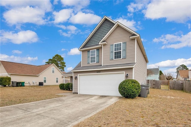 view of front of home with an attached garage, fence, and driveway