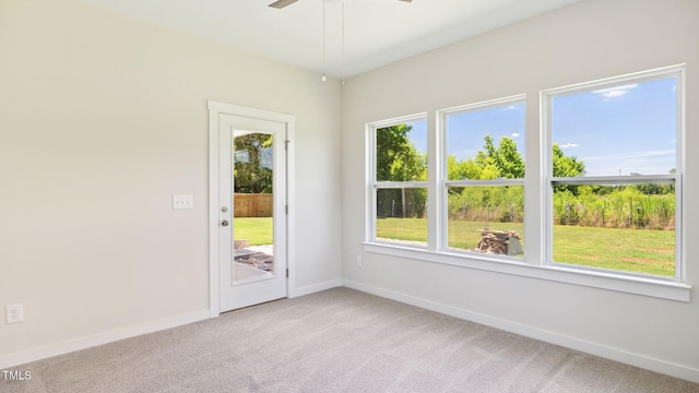 unfurnished room featuring a ceiling fan, light colored carpet, and baseboards