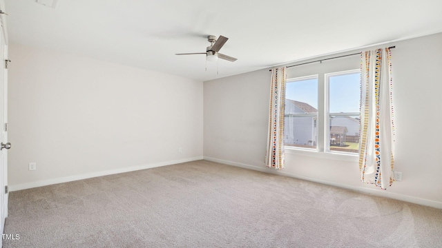 unfurnished room with ceiling fan, baseboards, and carpet