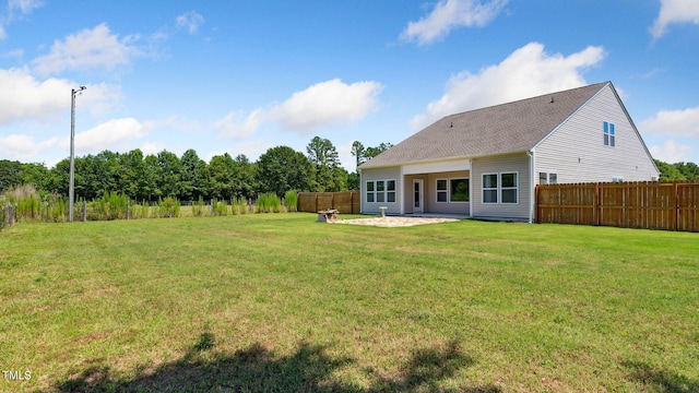 rear view of property with a patio area, a lawn, and fence