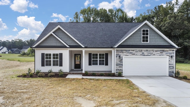 view of front of home featuring a garage, stone siding, covered porch, and concrete driveway