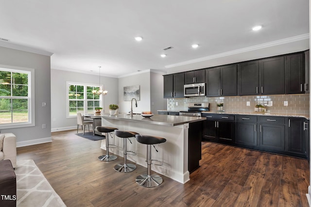 kitchen featuring visible vents, a breakfast bar, stainless steel appliances, decorative backsplash, and dark wood-style flooring