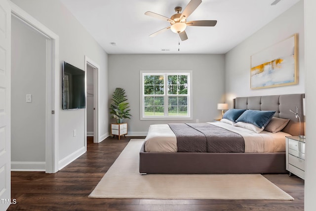 bedroom featuring ceiling fan, baseboards, and dark wood finished floors