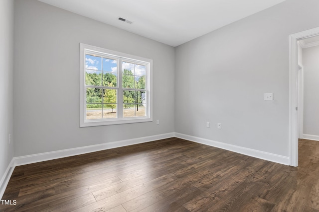 unfurnished room featuring visible vents, baseboards, and dark wood-style flooring