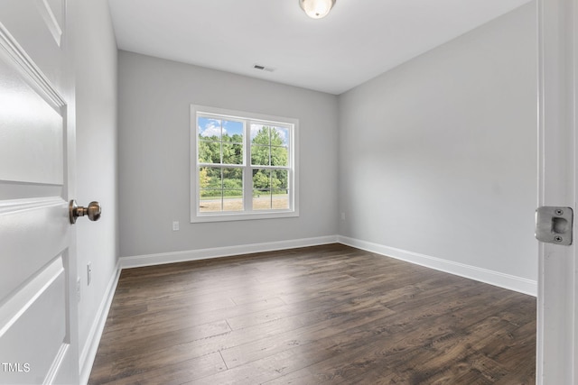 unfurnished room with dark wood finished floors, baseboards, and visible vents