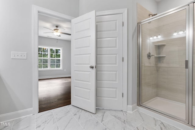 bathroom with baseboards, marble finish floor, a stall shower, and a ceiling fan