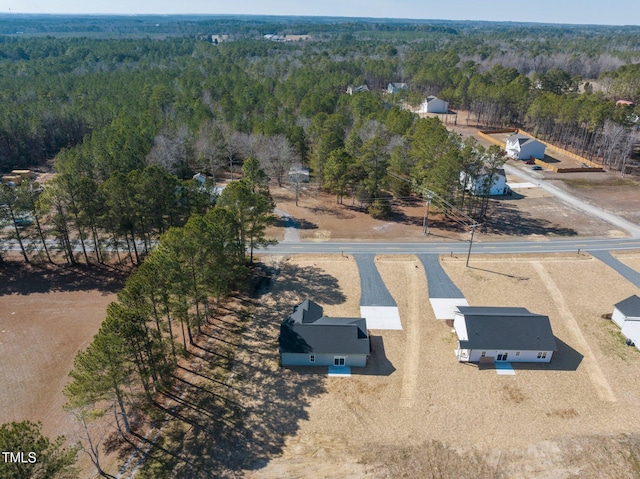 birds eye view of property featuring a forest view