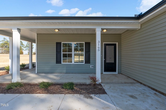 view of exterior entry with a porch