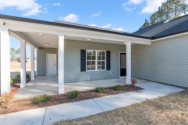 property entrance with a porch and a shingled roof