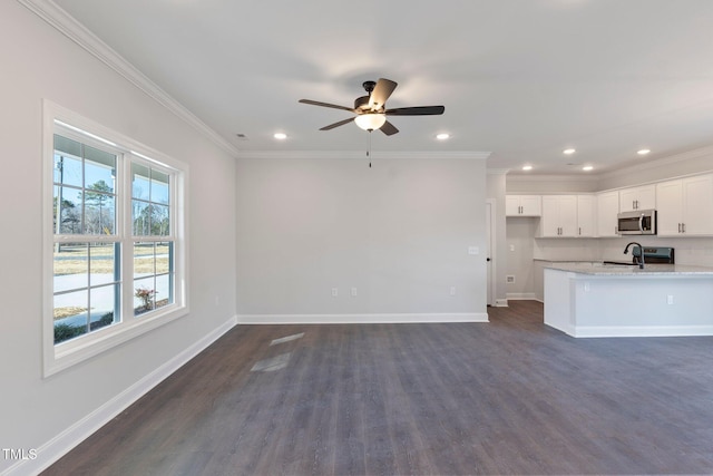 kitchen featuring ornamental molding, baseboards, appliances with stainless steel finishes, and a sink