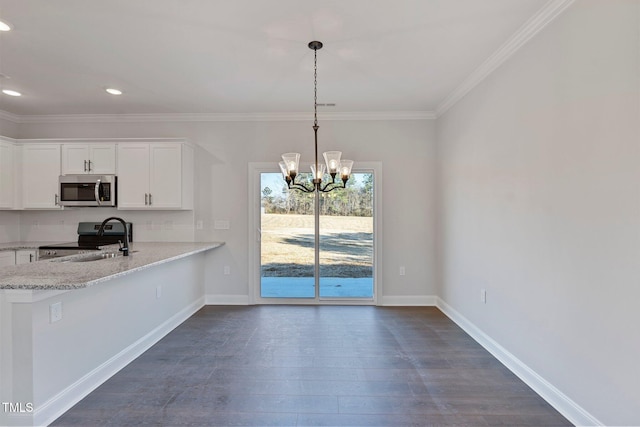 kitchen with stainless steel appliances, baseboards, a chandelier, and white cabinets