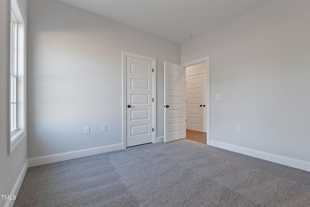 unfurnished bedroom featuring carpet and baseboards