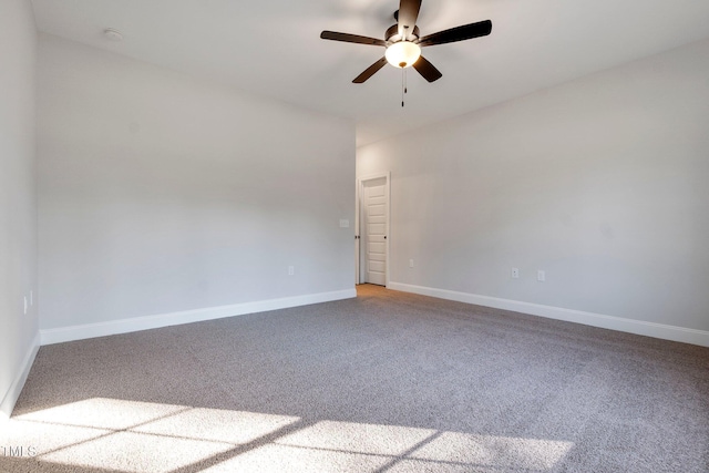 carpeted spare room with a ceiling fan and baseboards