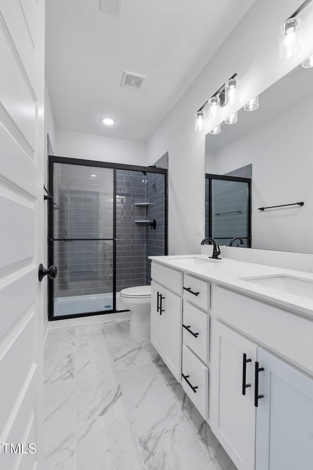 full bath featuring visible vents, double vanity, a stall shower, marble finish floor, and a sink