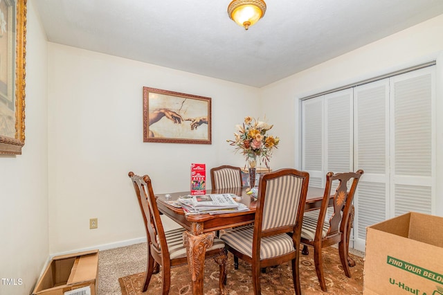 dining area featuring carpet and baseboards