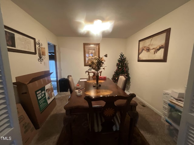 carpeted dining area with a fireplace and baseboards