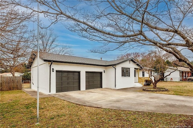 view of side of home featuring fence, roof with shingles, concrete driveway, a garage, and a lawn