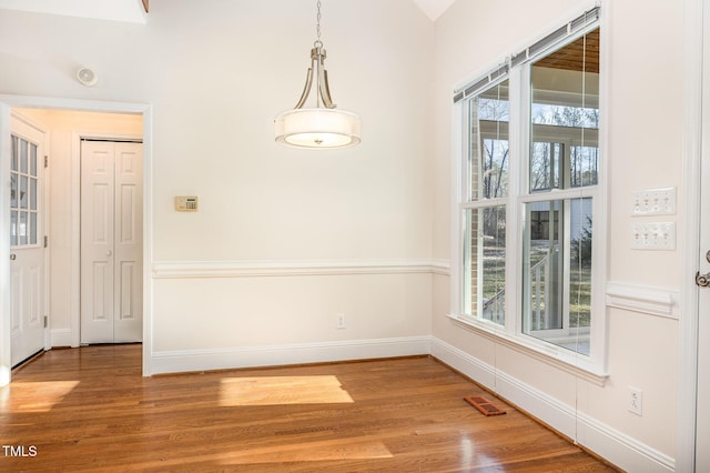 unfurnished dining area featuring visible vents, baseboards, and light wood-style flooring