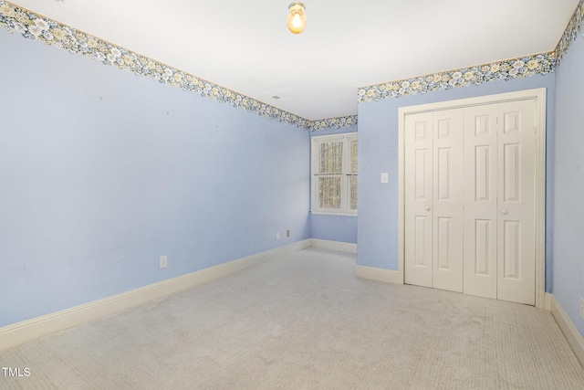 unfurnished bedroom featuring a closet, baseboards, and carpet floors