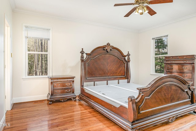 bedroom with baseboards, light wood-style floors, ceiling fan, and crown molding