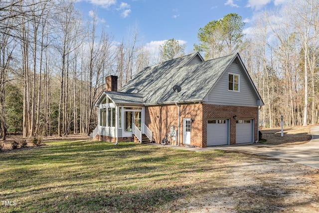 view of front facade with concrete driveway, a front yard, a sunroom, a garage, and brick siding