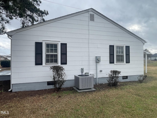 view of home's exterior with crawl space, a lawn, and central AC