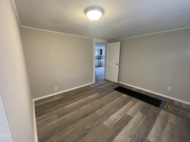 unfurnished room with dark wood-type flooring, crown molding, and baseboards