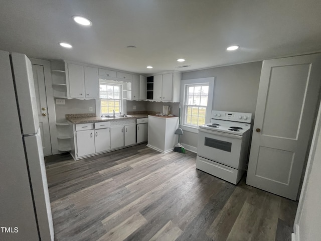 kitchen featuring white appliances, wood finished floors, open shelves, white cabinets, and a wealth of natural light