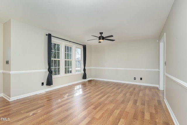 empty room with light wood-style flooring, visible vents, baseboards, and ceiling fan