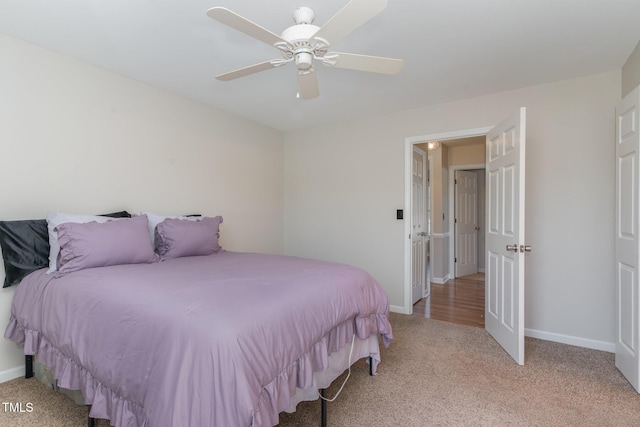 bedroom featuring baseboards, light colored carpet, and ceiling fan