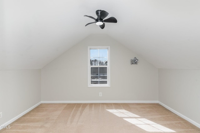 additional living space featuring lofted ceiling, baseboards, and light carpet