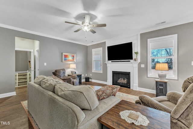 living room featuring visible vents, dark wood finished floors, a fireplace, a healthy amount of sunlight, and ceiling fan