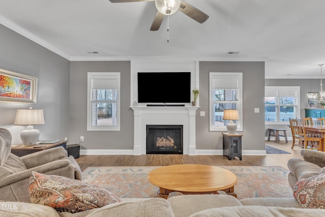 living area featuring a ceiling fan, plenty of natural light, a fireplace, and visible vents