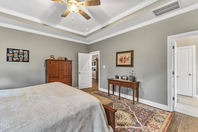 bedroom featuring visible vents, ceiling fan, baseboards, ornamental molding, and wood finished floors